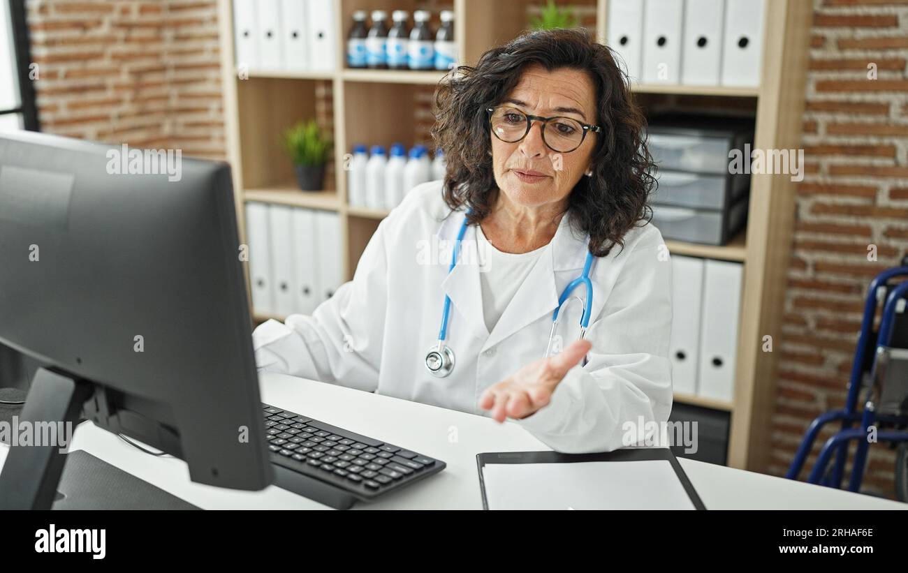 How Docor Use Computer Middle age hispanic woman doctor using computer speaking at the clinic ...