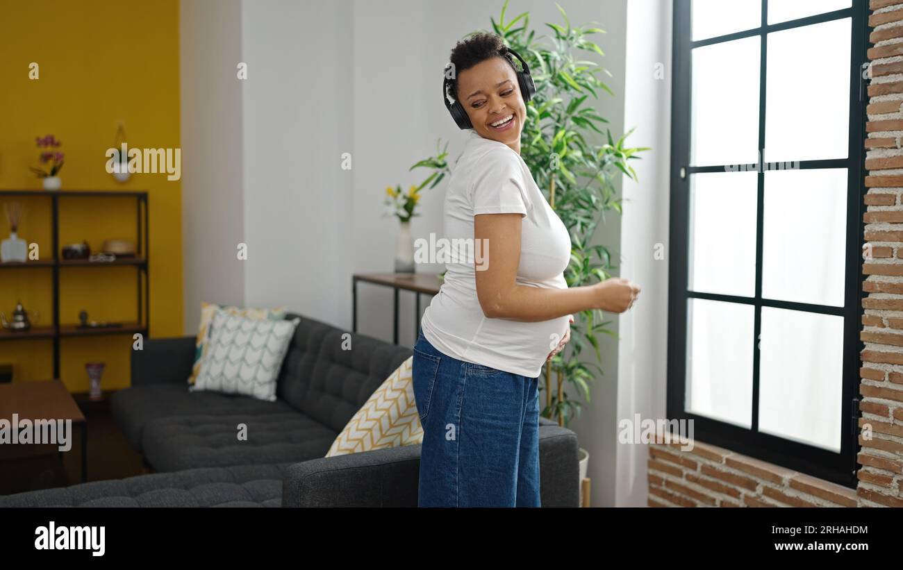 Young pregnant woman listening to music dancing at home Stock Photo - Alamy
