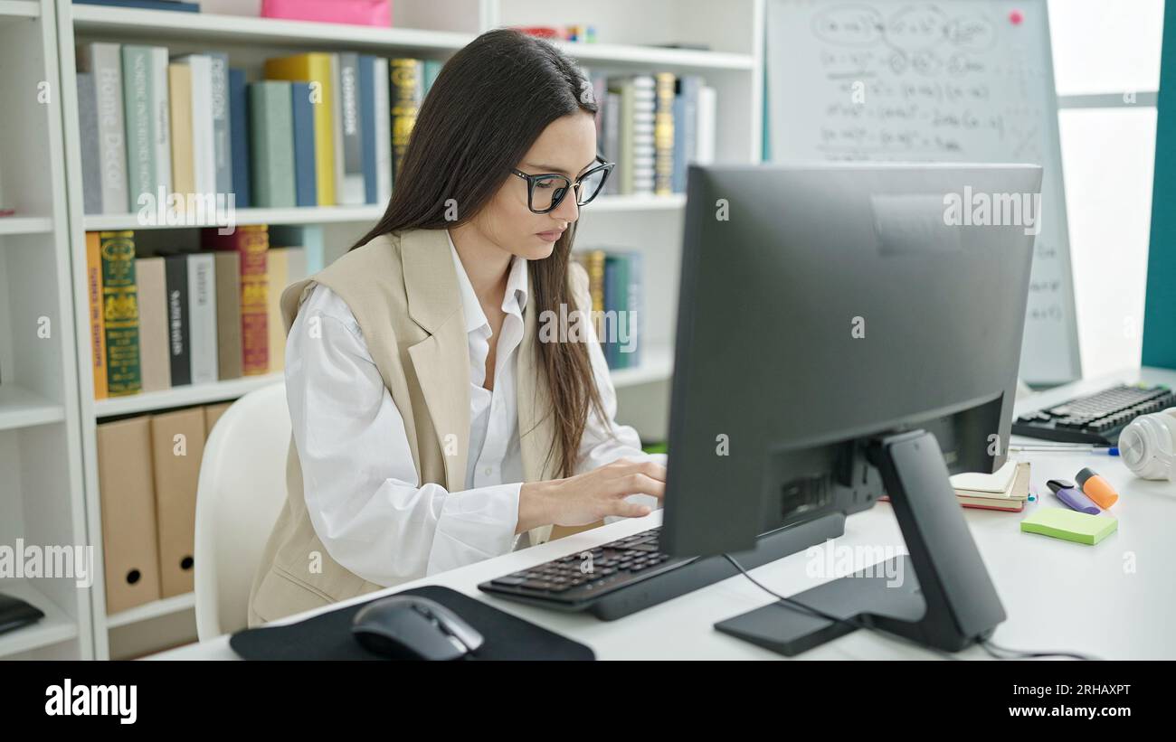 Young beautiful hispanic woman student using computer studying at ...