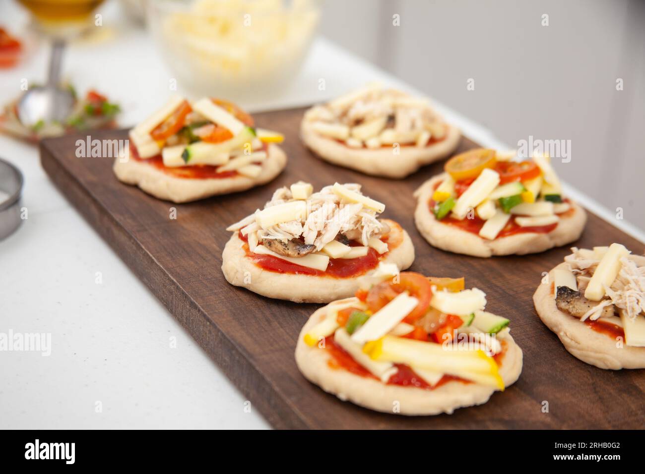 Ready to be baked mini pizzas. Delicious home made mini pizzas preparation. Stock Photo