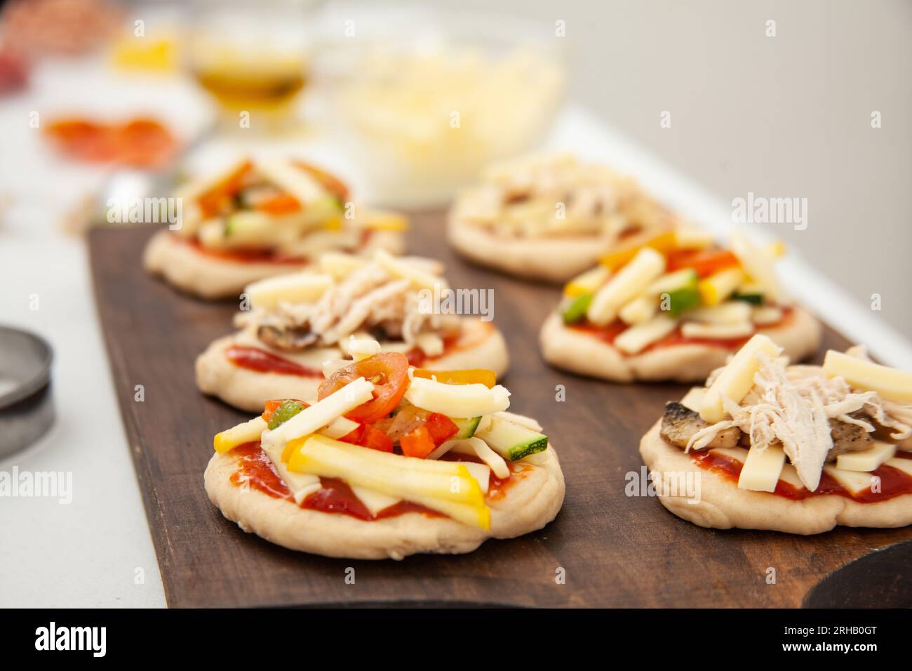 Ready to be baked mini pizzas. Delicious home made mini pizzas preparation. Stock Photo