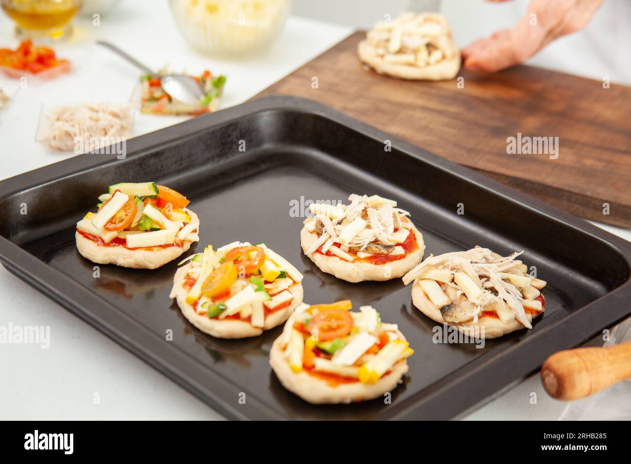 Ready to be baked mini pizzas. Delicious home made mini pizzas preparation. Stock Photo