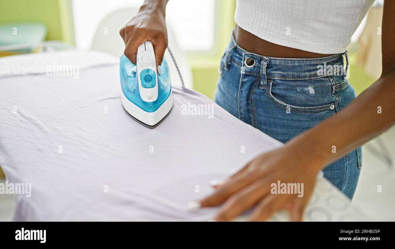 https://c8.alamy.com/comp/2RHB35P/african-american-woman-ironing-clothes-at-laundry-room-2RHB35P.jpg