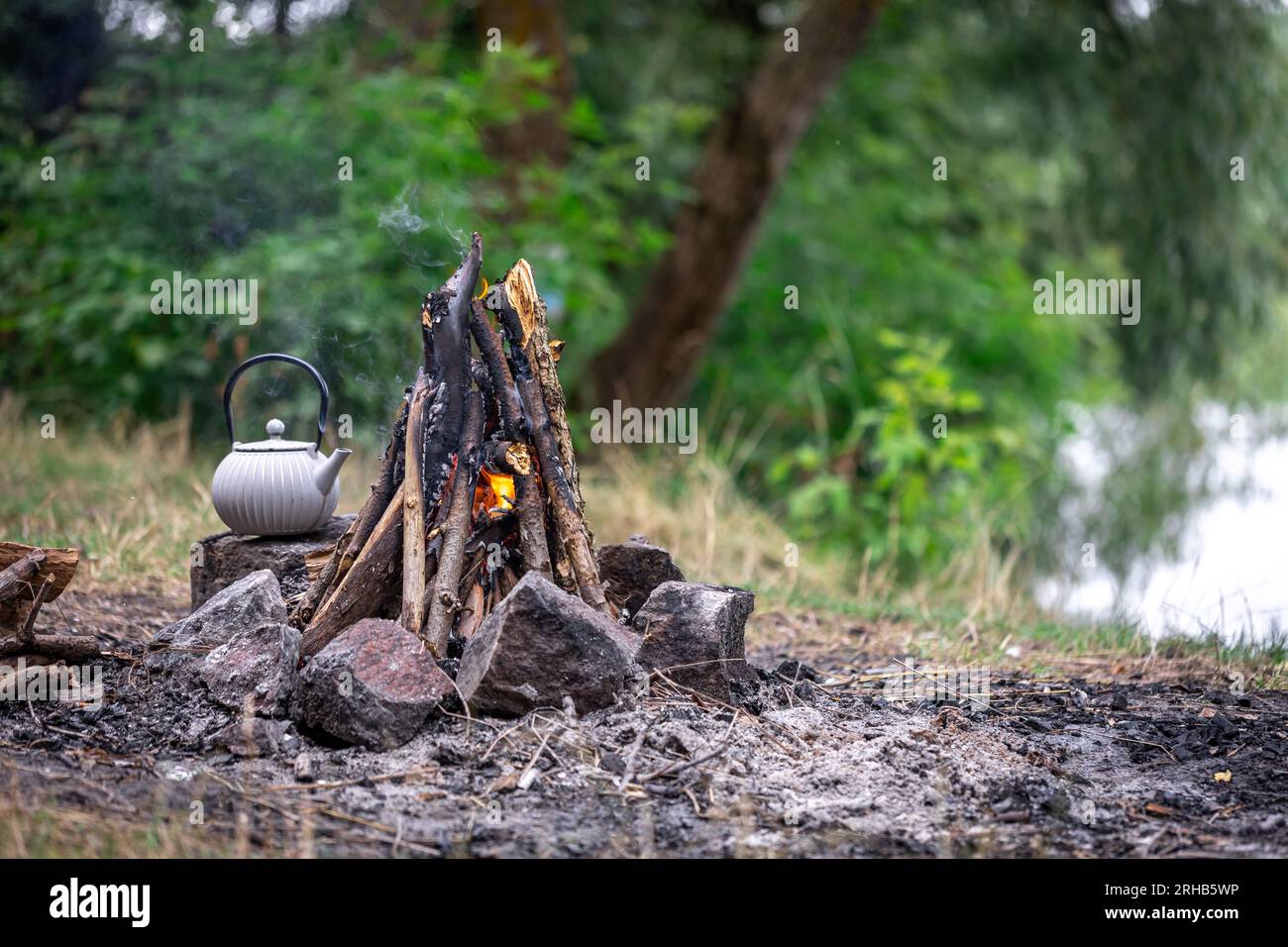 https://c8.alamy.com/comp/2RHB5WP/small-kettle-is-heated-on-a-bonfire-outdoor-recreation-concept-2RHB5WP.jpg