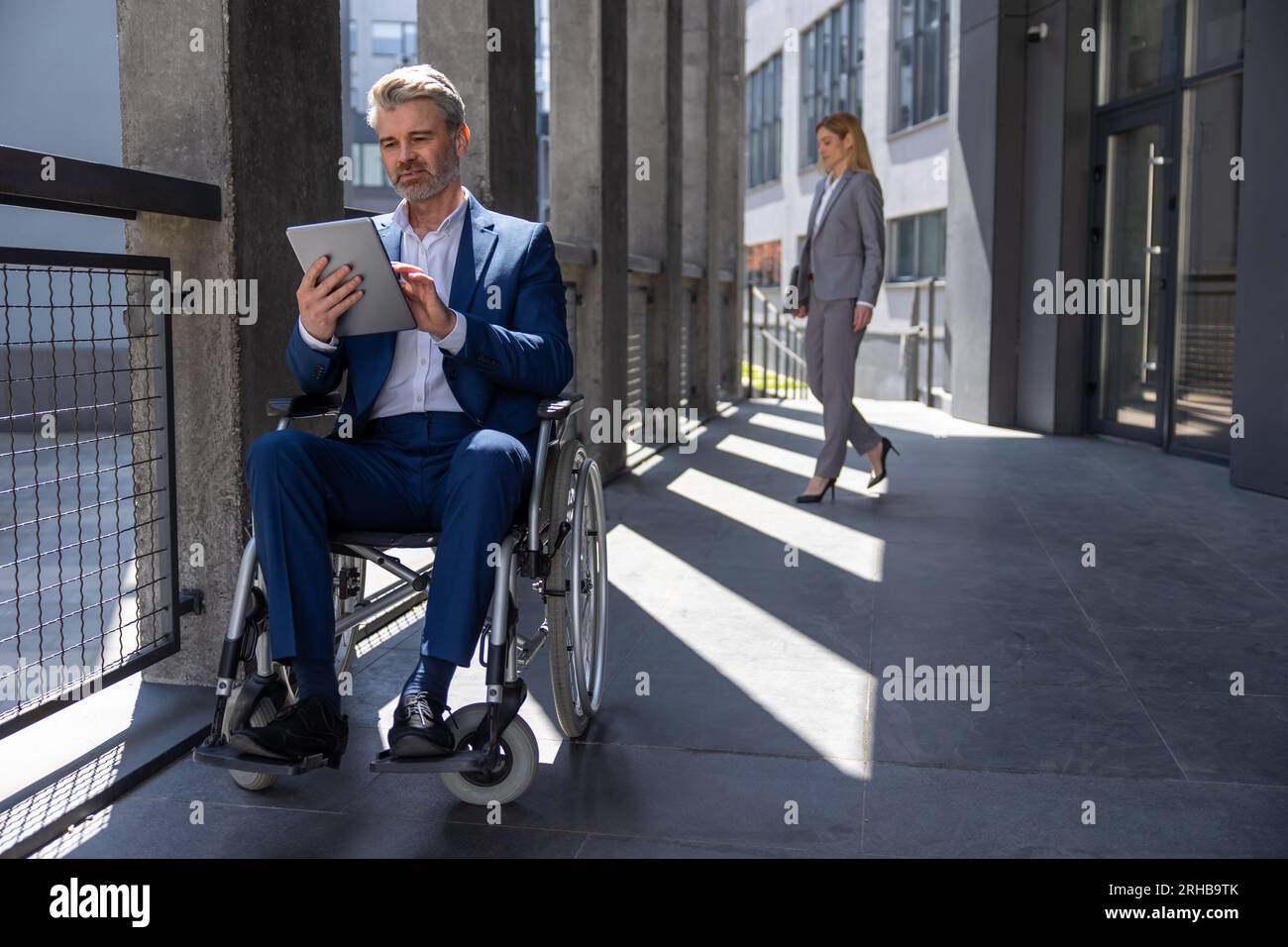 Executive business man in wheelchair with tablet using mobile device ...
