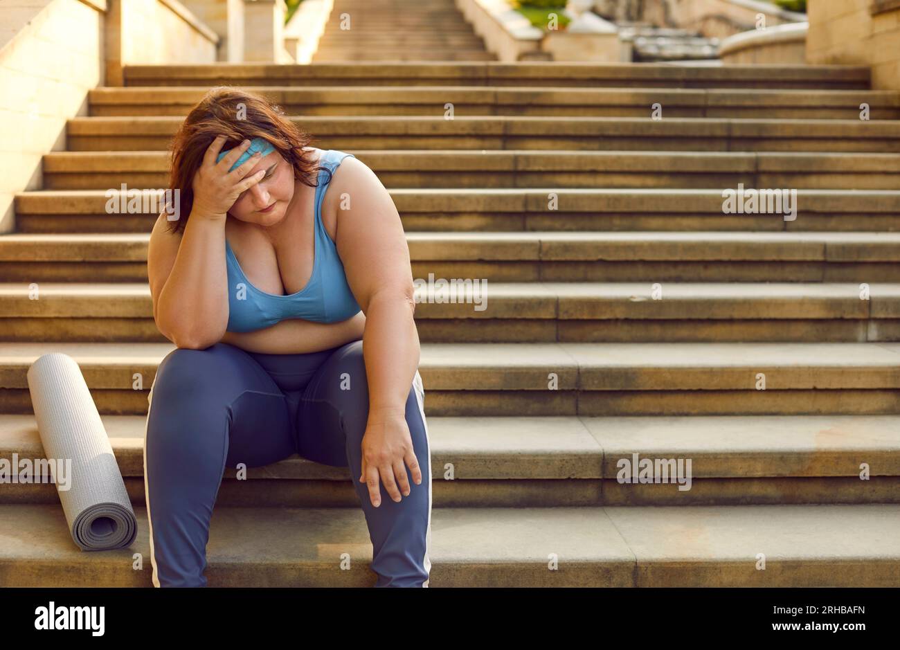 Sad Exhausted Overweight Woman With Fitness Workout Mat Is Sitting On Sad Exhausted Overweight Woman With Fitness Workout Mat Is Sitting On