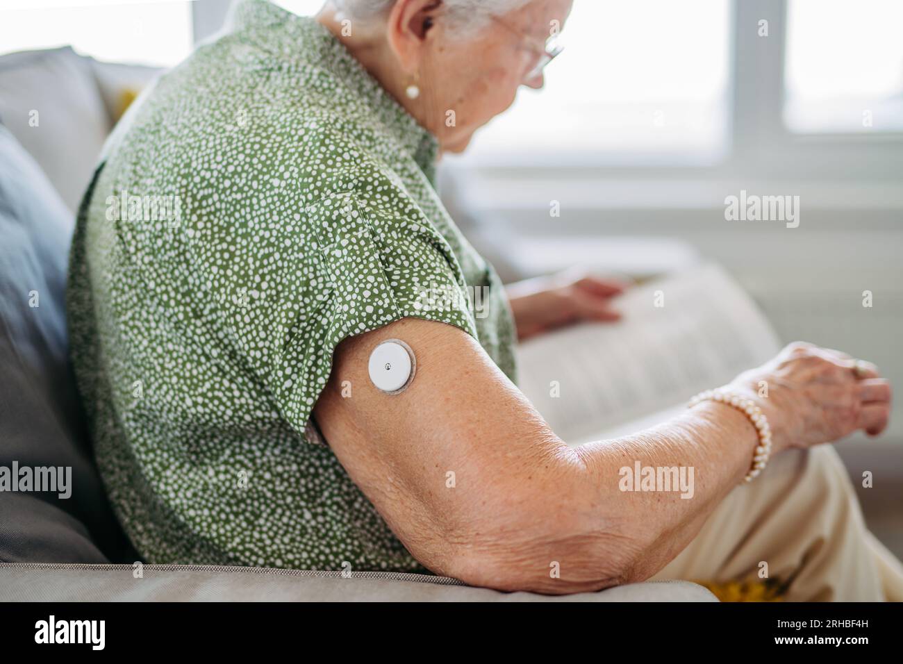 Diabetic senior patient using continuous glucose monitor to check blood