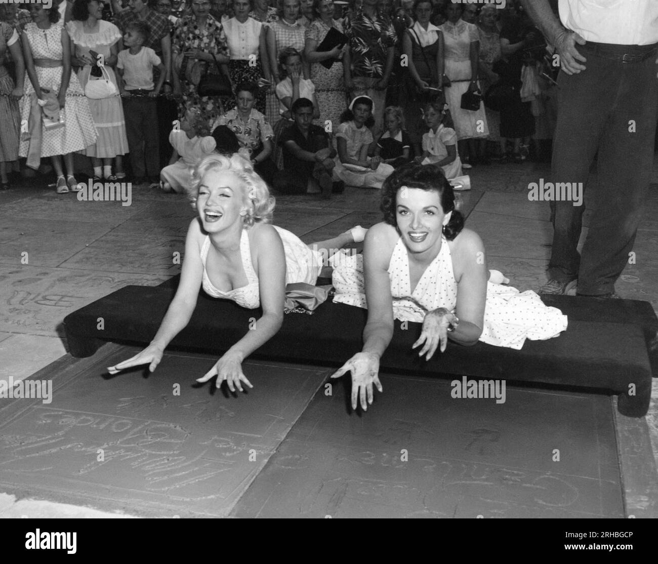 Hollywood, California:  June 26, 1953 Actresses Marilyn Monroe {L) and Jane Russell put their handprints in wet cement at Grauman's Chinese Theater to promote their latest film, 'Gentlemen Prefer Blondes'. Stock Photo