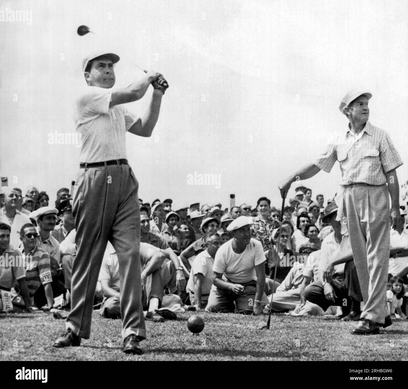 Rockville, Maryland: 1953 Vice-President Richard Nixon tees off at the National Celebrities Open Tournament at the Woodmont Country Club. Bob Hope at right smiles as he watches the ball heading for spectators. Nixon, a newcomer to the sport, twice sent spectators ducking on the first hole. Stock Photo