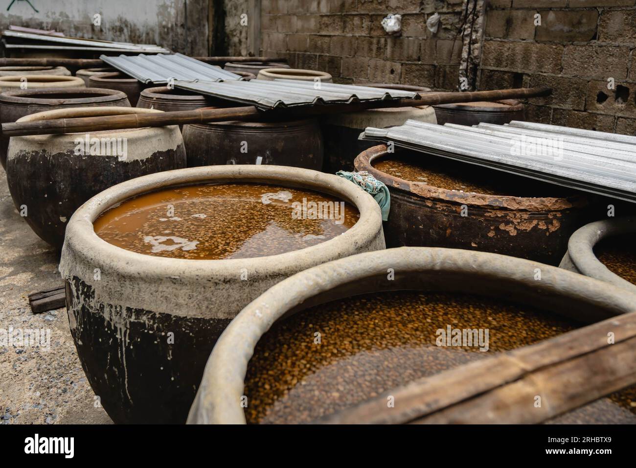 Soybeans with brine in a jar under sunlight are fermenting, one of the  six-step process, at the century Hao Yong Seng homemade soy sauce factory,  in Khlong Bang Luang, historical community along