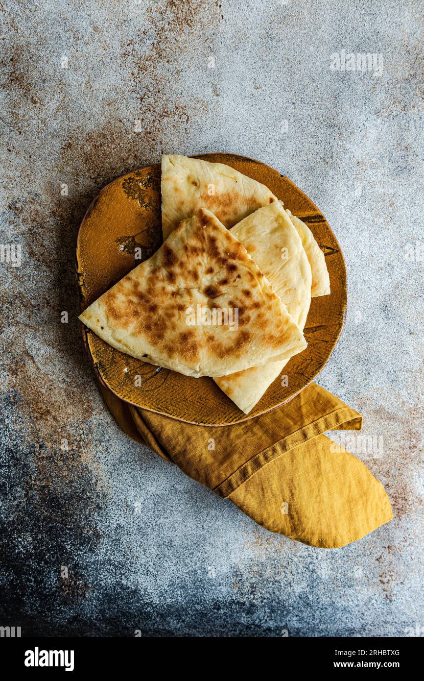 Overhead view of Georgian cheese bread slices (Imeruli khachapuri) on a plate Stock Photo