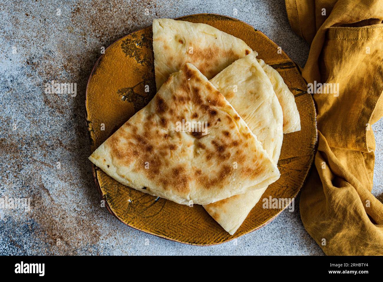Overhead view of Georgian cheese bread slices (Imeruli khachapuri) on a plate Stock Photo