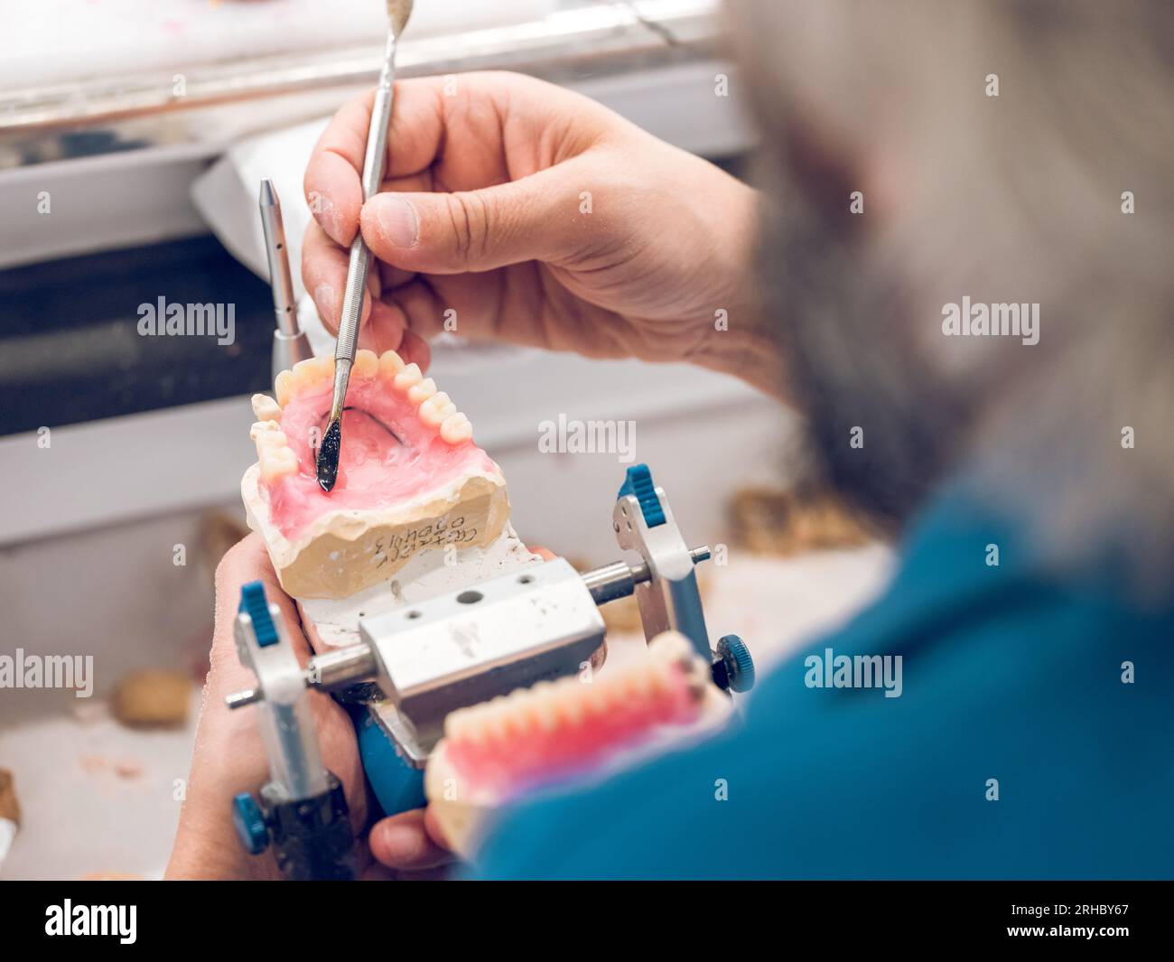 From above of crop faceless male orthodontist using dental spatula for