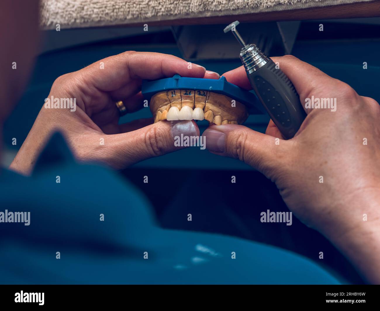 From above of crop anonymous male specialist grinding fake ceramic