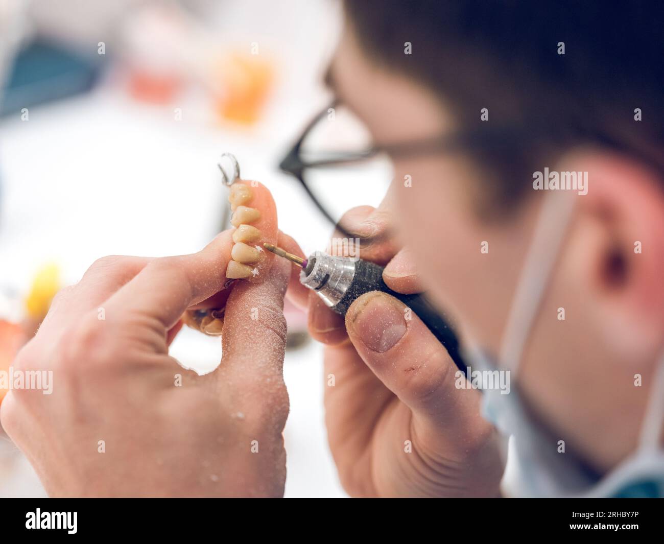 From above of crop unrecognizable male orthodontist polishing jaw