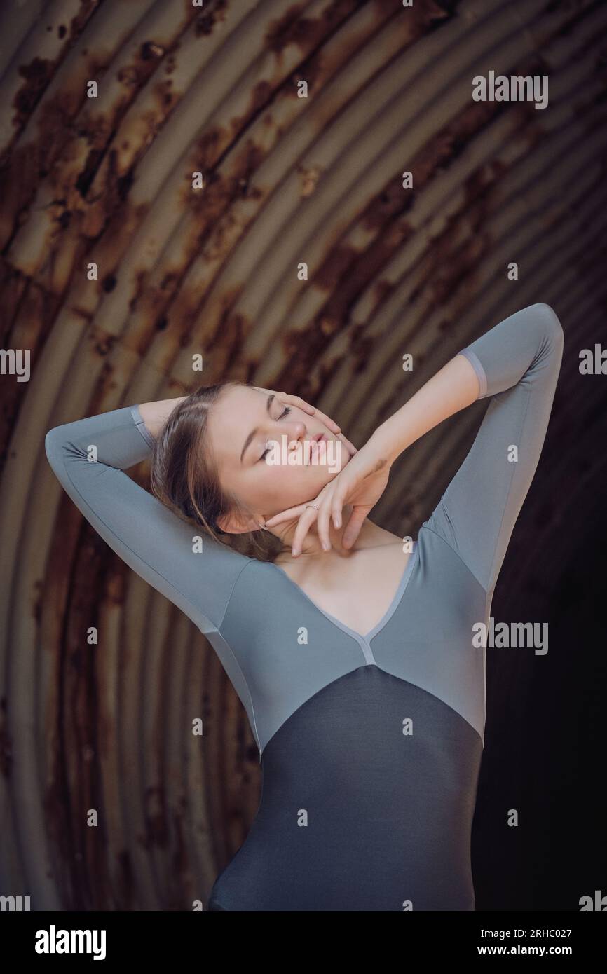 Attractive fit young female ballet dancer touching head with closed ...