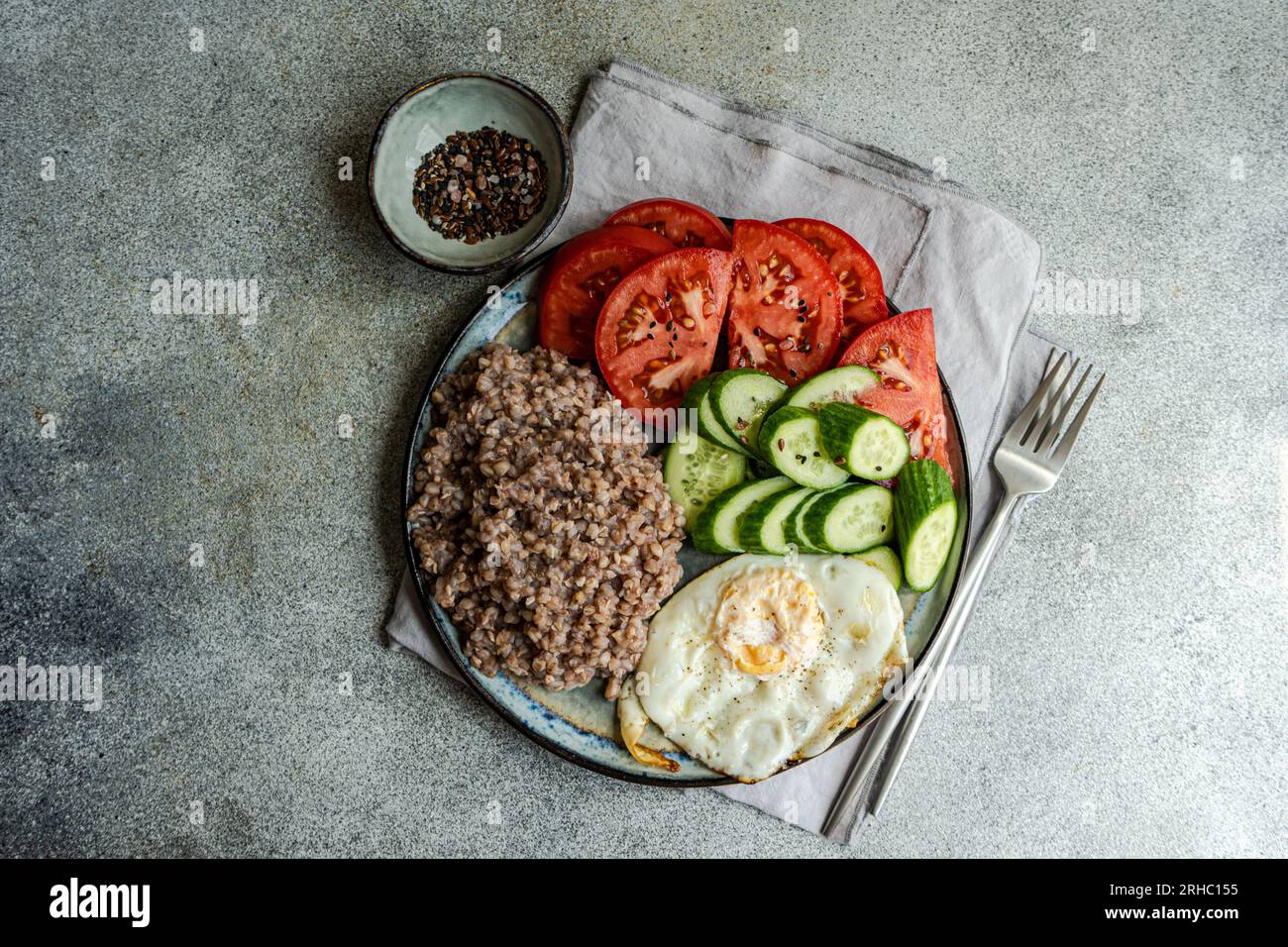 Overhead view of a healthy lunch plate with buckwheat, cucumber, tomato and a fried egg Stock Photo