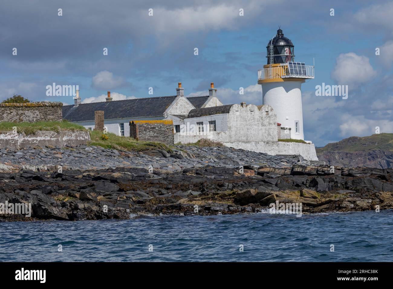 Lighthouse and its surrounding buildings on a scottish island Stock Photo