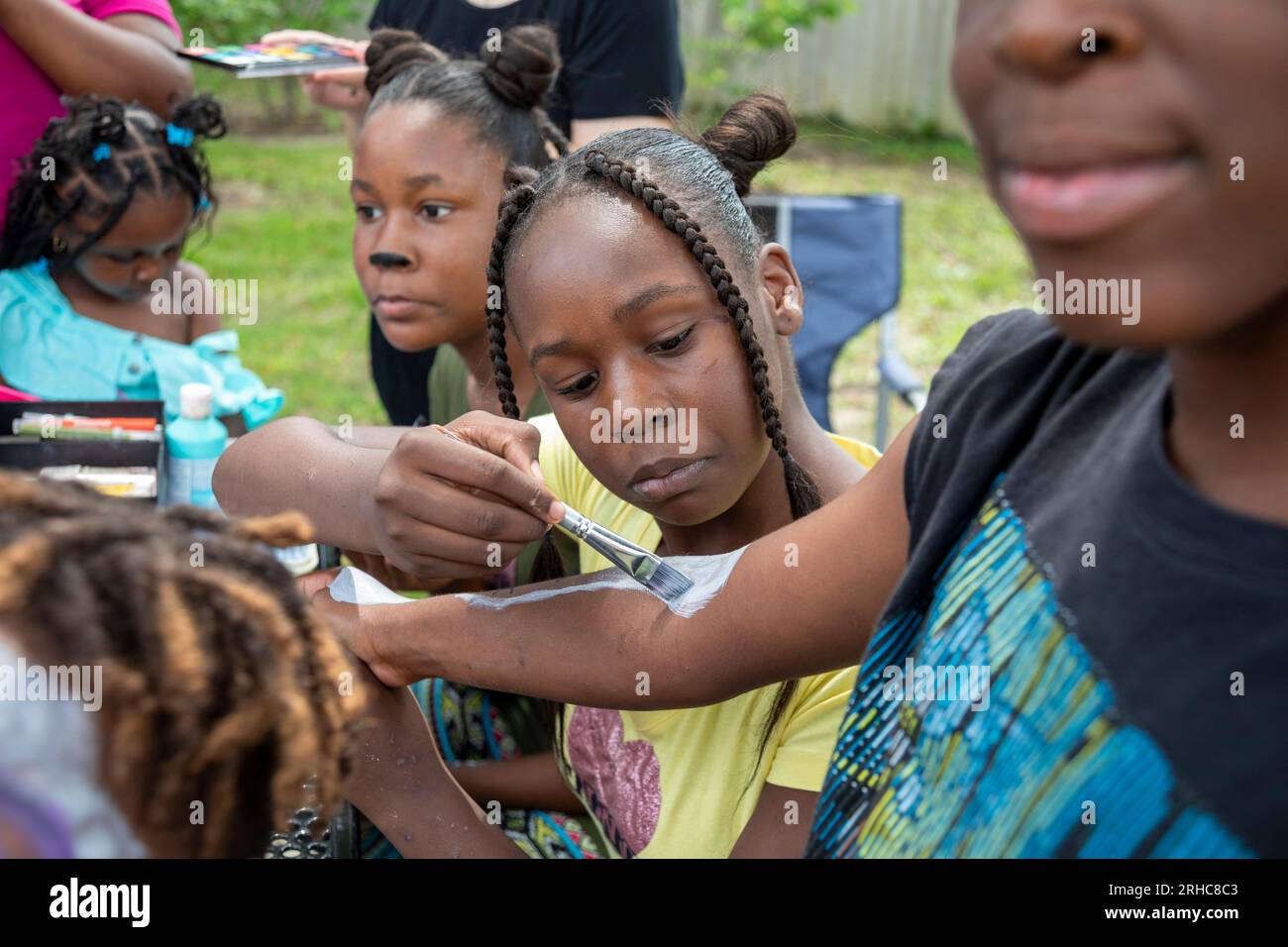 Detroit, Michigan - Children enjoy face and body painting as the the Morningside neighborhood holds a picnic/party called the 'Summer Sizzler.' It was Stock Photo