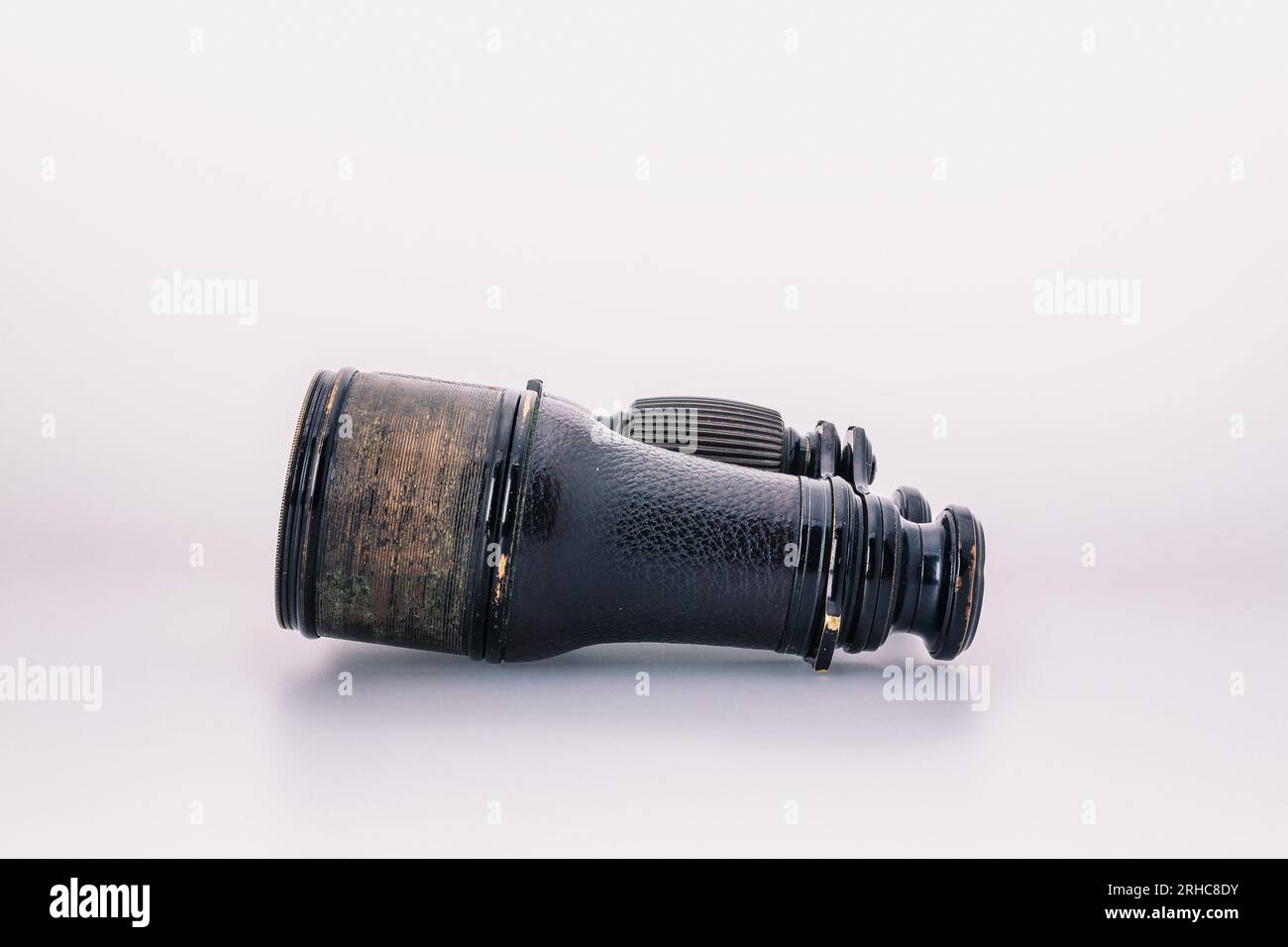 Antique oxidized binoculars from last century, with signs of time, isolated on white, rusted optics, reflecting a romanticized view of discovery and e Stock Photo
