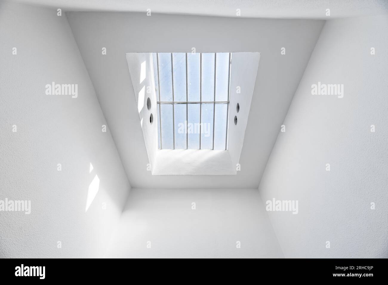Skylight in the roof of a house with white painted walls and