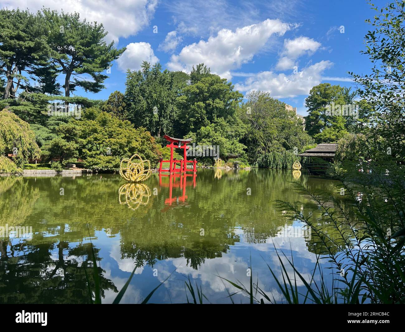 The Flowers of Hypnosis; by French artist Jean-Michel Othoniel presents a new series of six large sculptures at Brooklyn Botanic Garden. Here seen next to the iconic Heaven's Gate in the pond of the Japanese Garden. Stock Photo