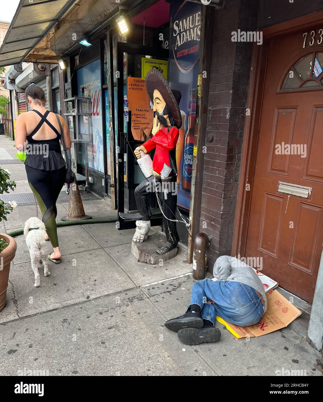 Homeless man sleeps by a doorway on Church Avenue in the Kensington