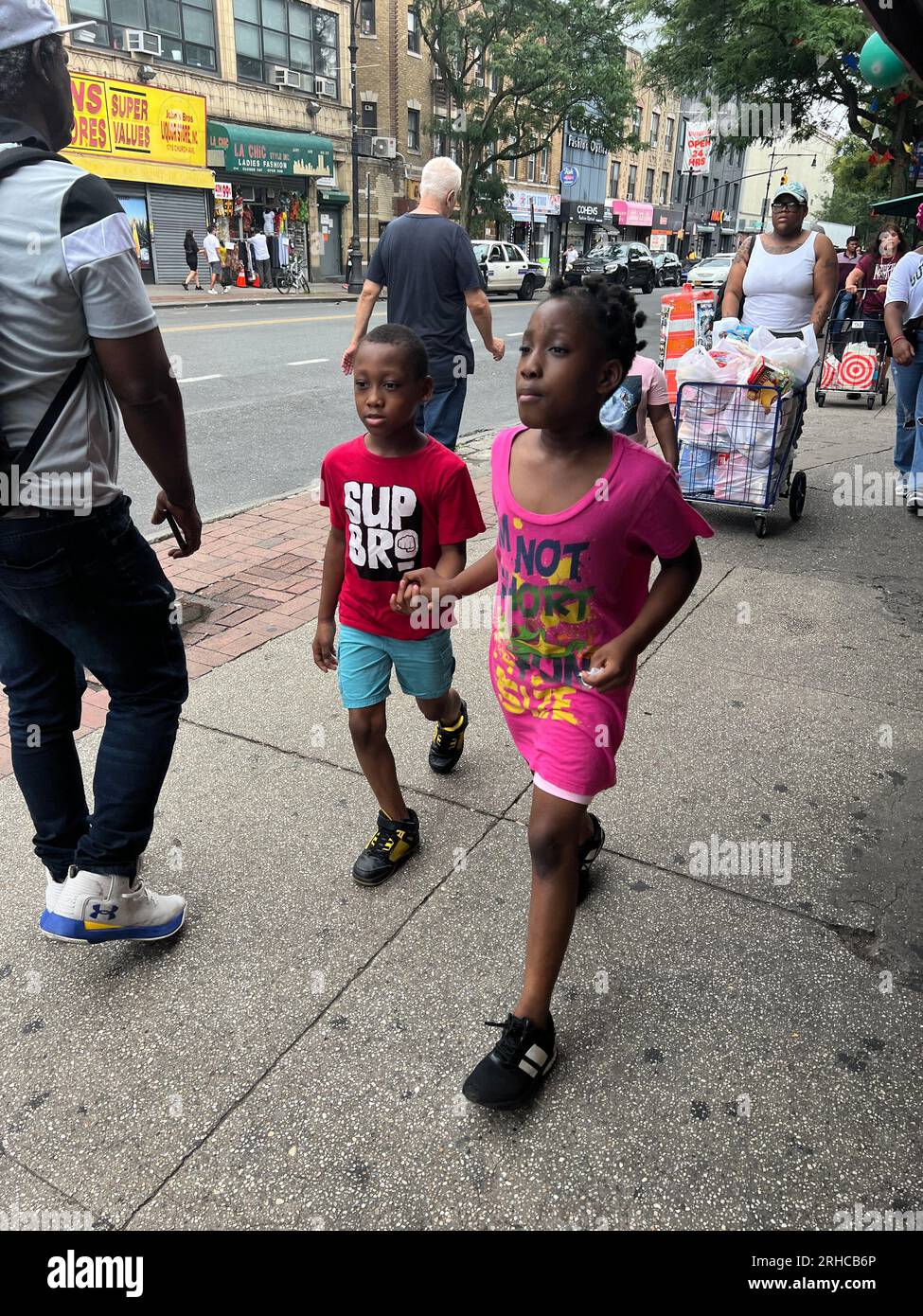 Brother and sister walk hand in hand along Church Avenue in the Flatbush neighborhood of Brooklyn, New York. Stock Photo
