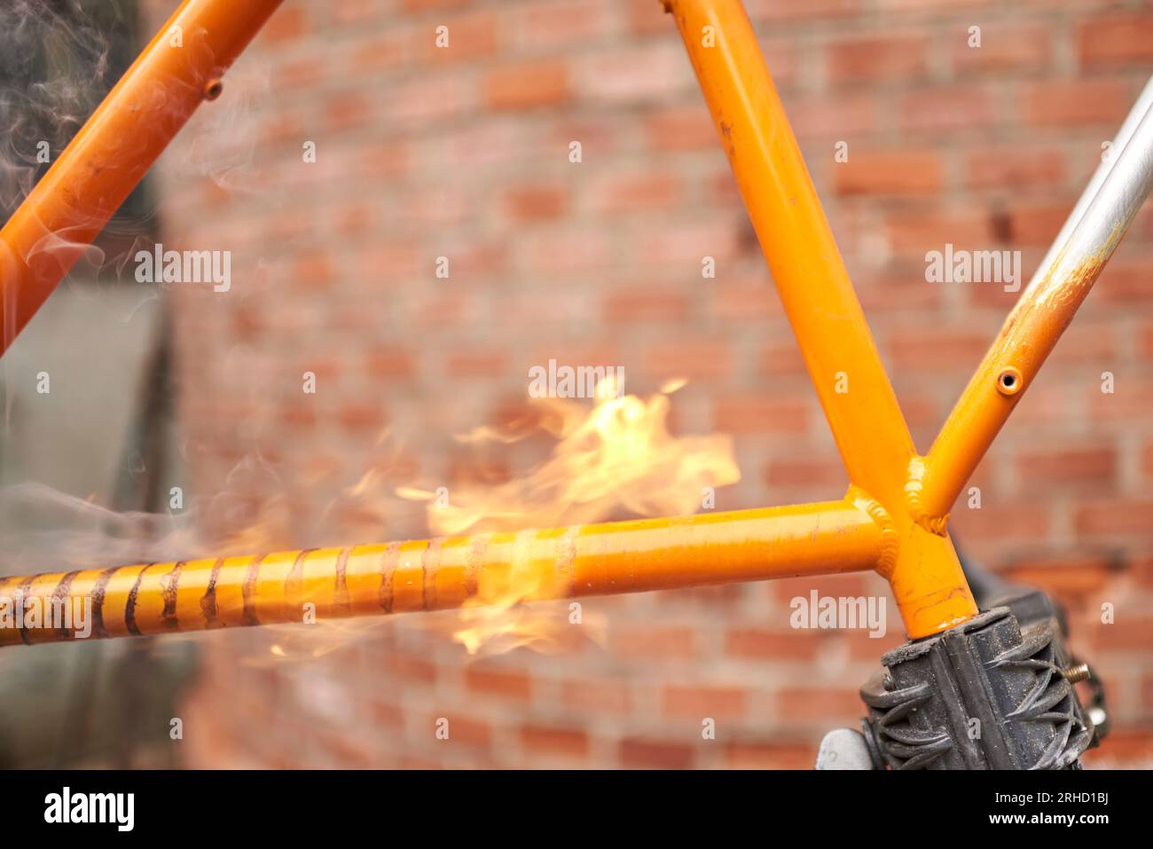 Manual bicycle renovation work, paint removal process using a torch