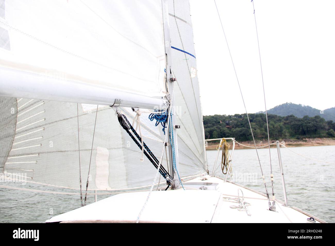Parts of a sailboat that is sailing on the lake with sails out, bow