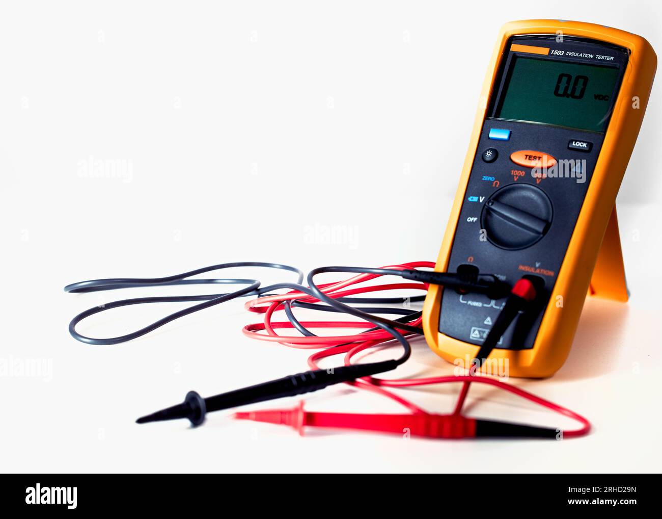 Digital multimeter with probes and green backlit display on a white background Stock Photo