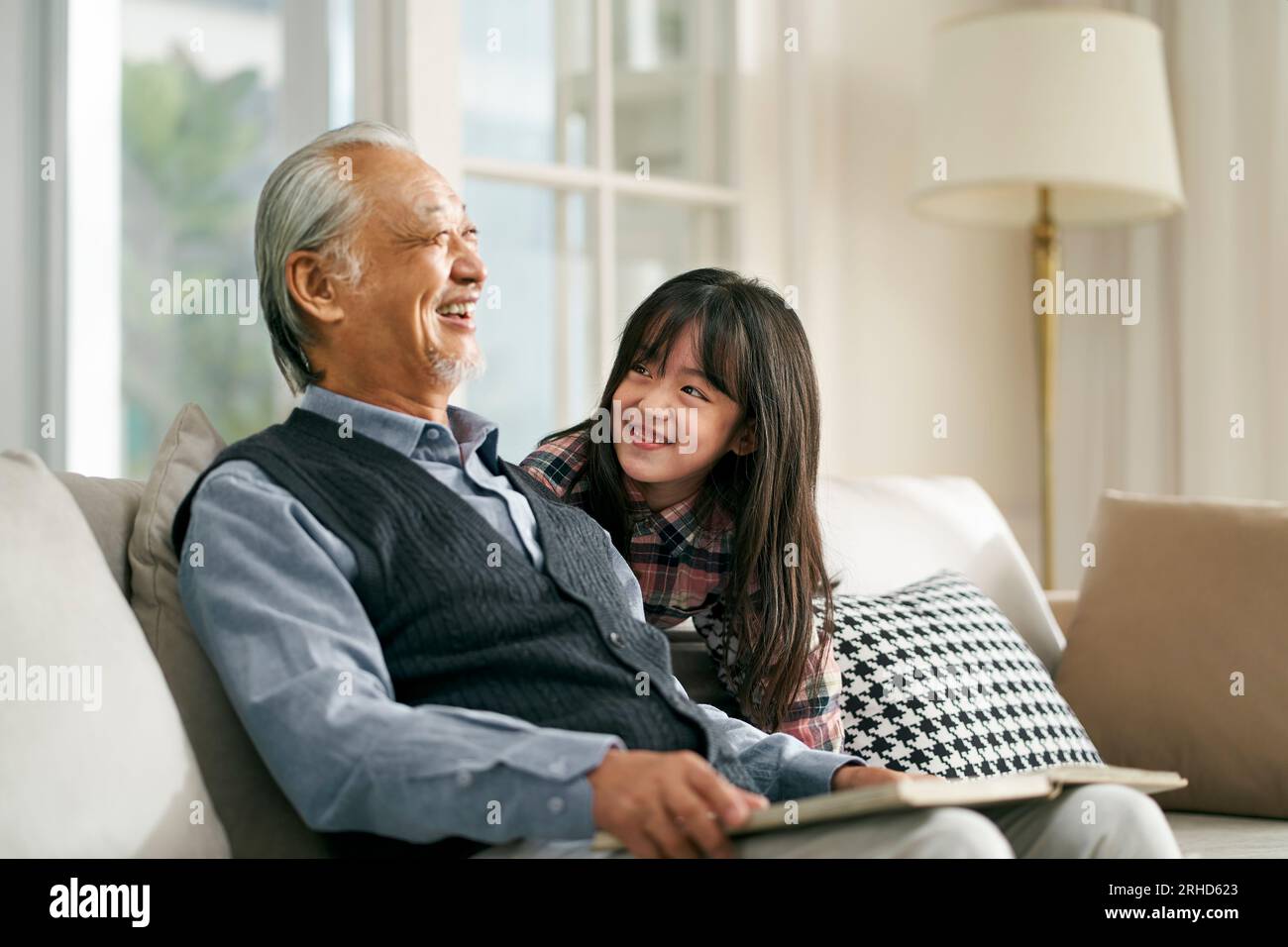 asian grandpa and granddaughter having a good time in living at home Stock Photo