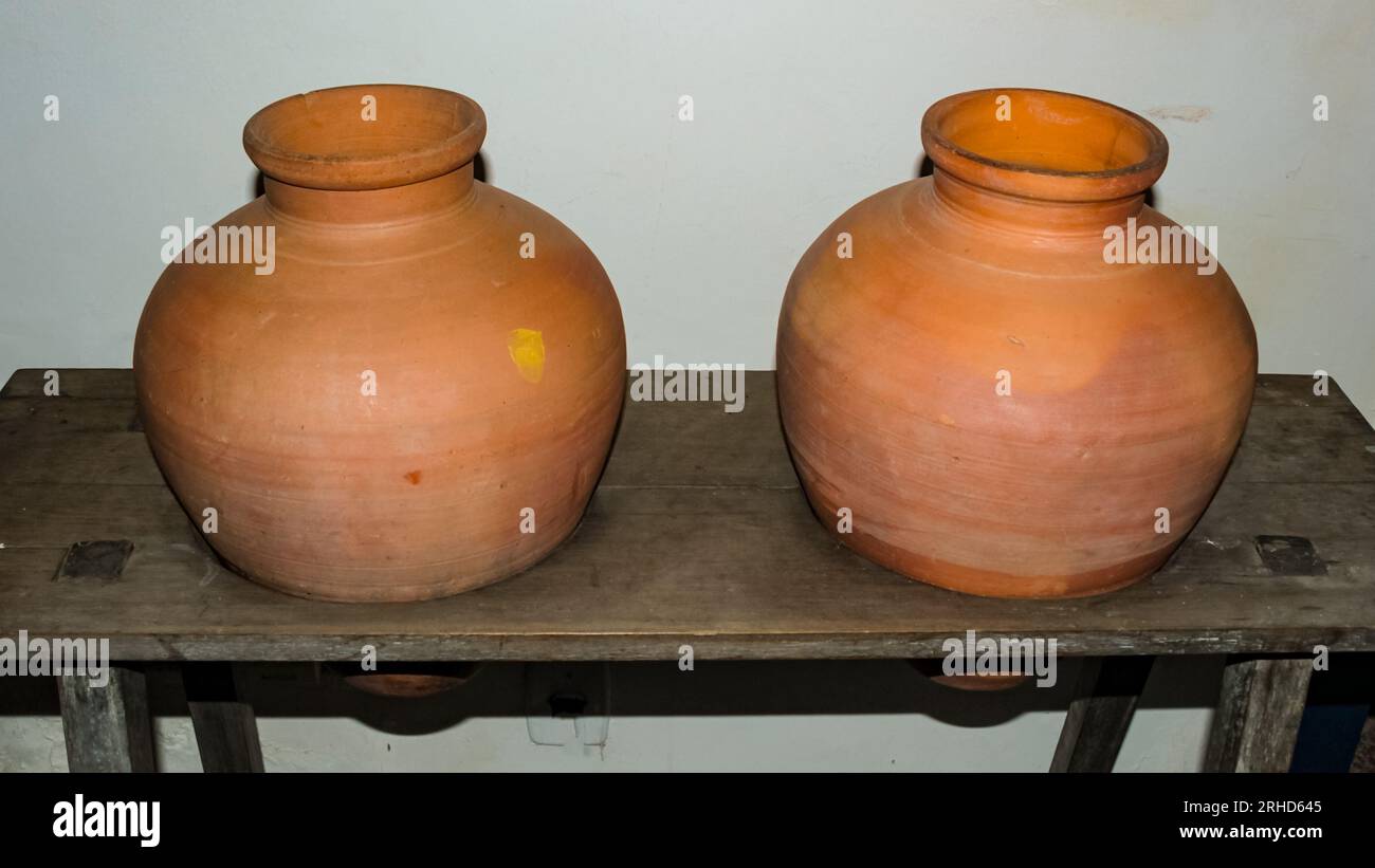Two large water jugs made of fired clay, called Potes in northeastern Brazil, mounted on a rustic wooden stand. Stock Photo