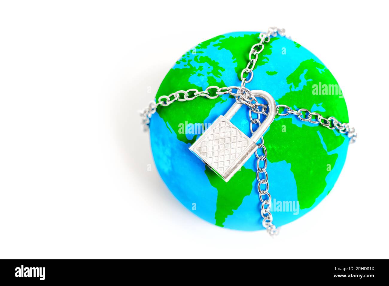 Globe trapped in chains and secured with a padlock isolated on white background. Visual metaphor for the need to break free from all constraints and w Stock Photo