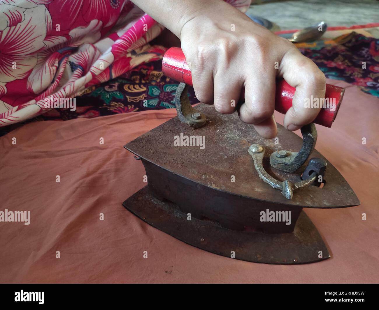 A woman ironing with an old fashioned charcoal iron at the Balukhali refugee camp. Approximately 919,000 Rohingya refugees are living at the Kutupalong and Nayapara camps in Cox’s Bazar region — which have grown to become some of the largest and most densely populated camps in the world. Bangladesh. Stock Photo