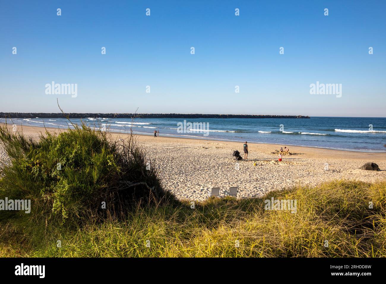 Family enjoys late afternoon winter sunshine on Turners beach in Yamba