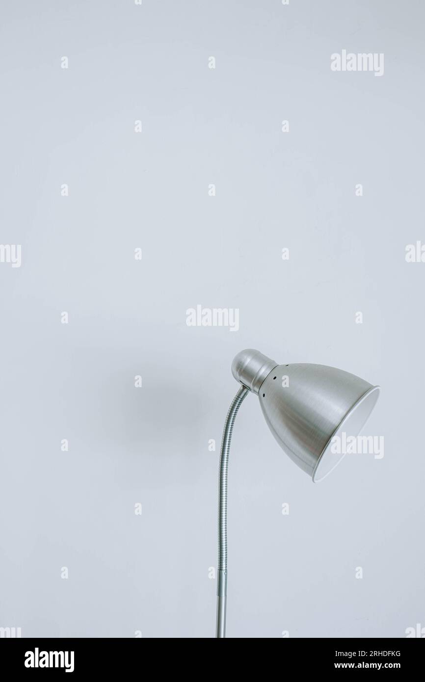 Portrait or vertical shot of a vintage and modern metal desk lamp on isolated white background Stock Photo