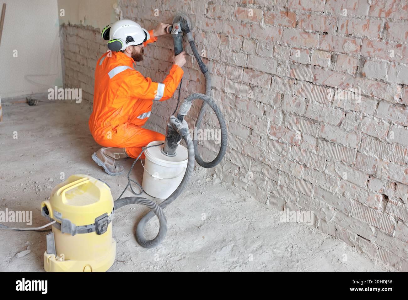 Construction worker using modern concrete wall grinding machine