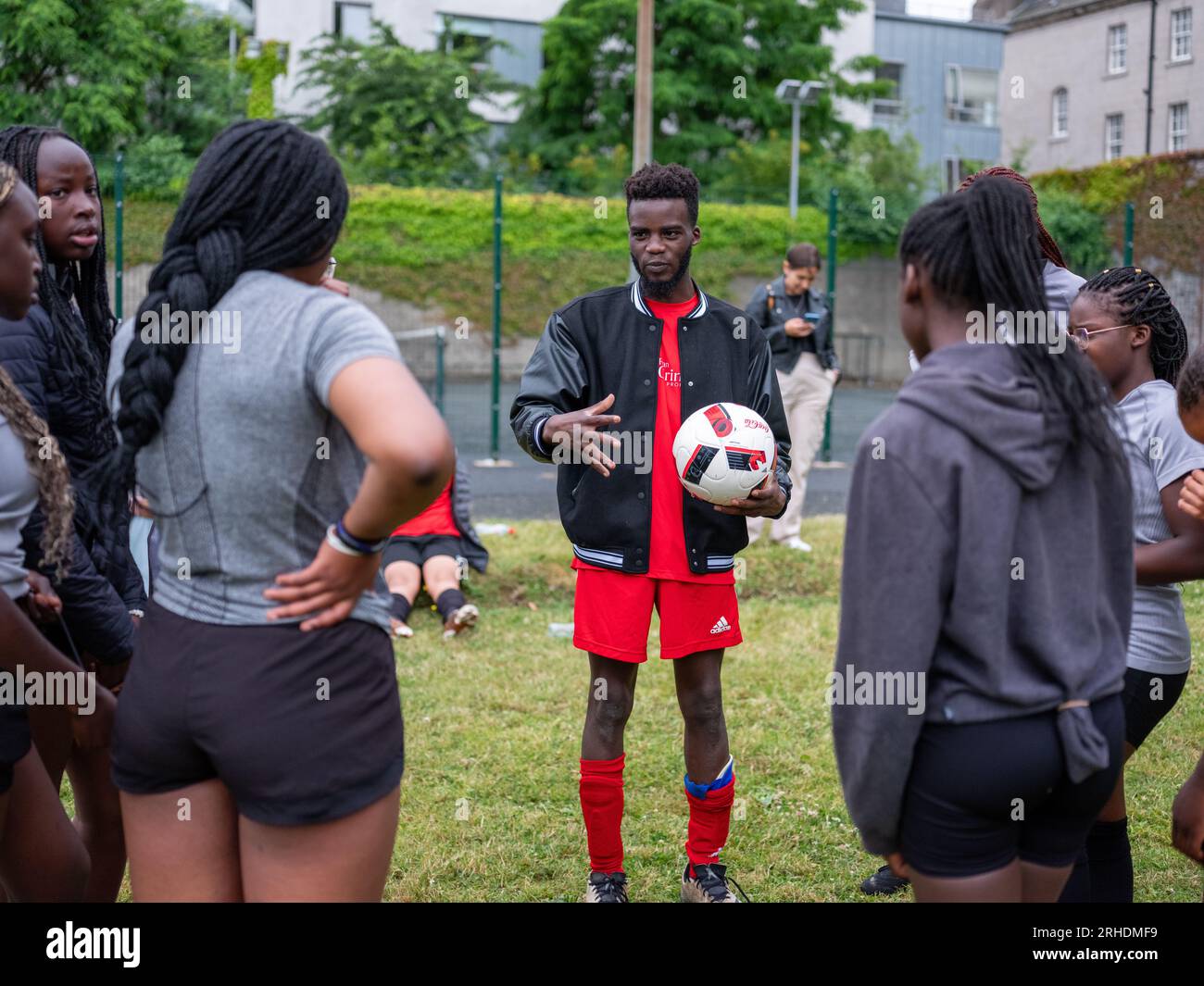 A young black male coaching a ladies football team. Stock Photo