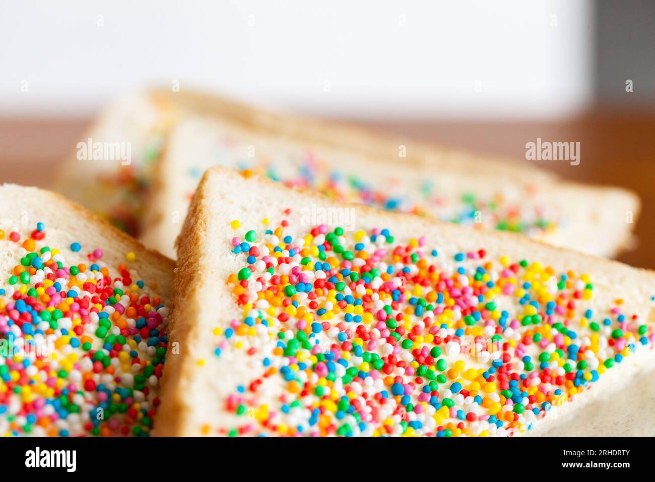 Triangles of australian children's party food, fairy bread made of white bread with sprinkles and butter Stock Photo