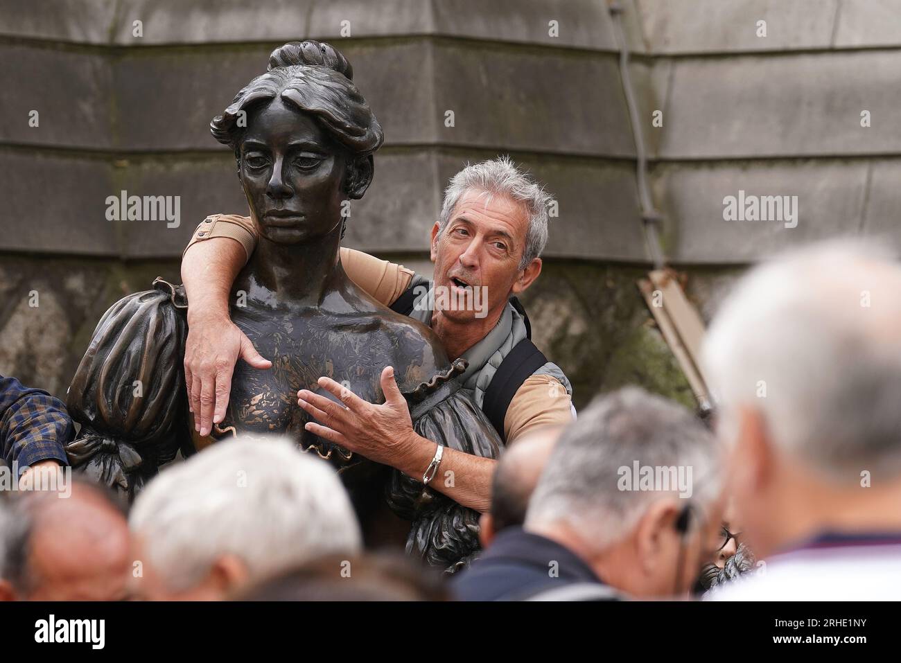 People pose for photographs with the iconic Molly Malone statue in Dublin's city centre after it was vandalised with black paint across it's front. The statue of the semi historical, semi-legendary figure is a popular tourist destination. Picture date: Wednesday August 16, 2023. Stock Photo