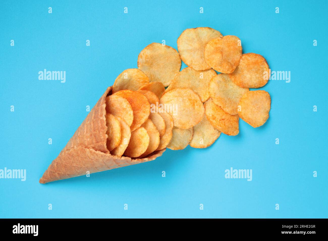Waffle Cone with Potato Chips on blue background. Fast Food concept close-up Stock Photo
