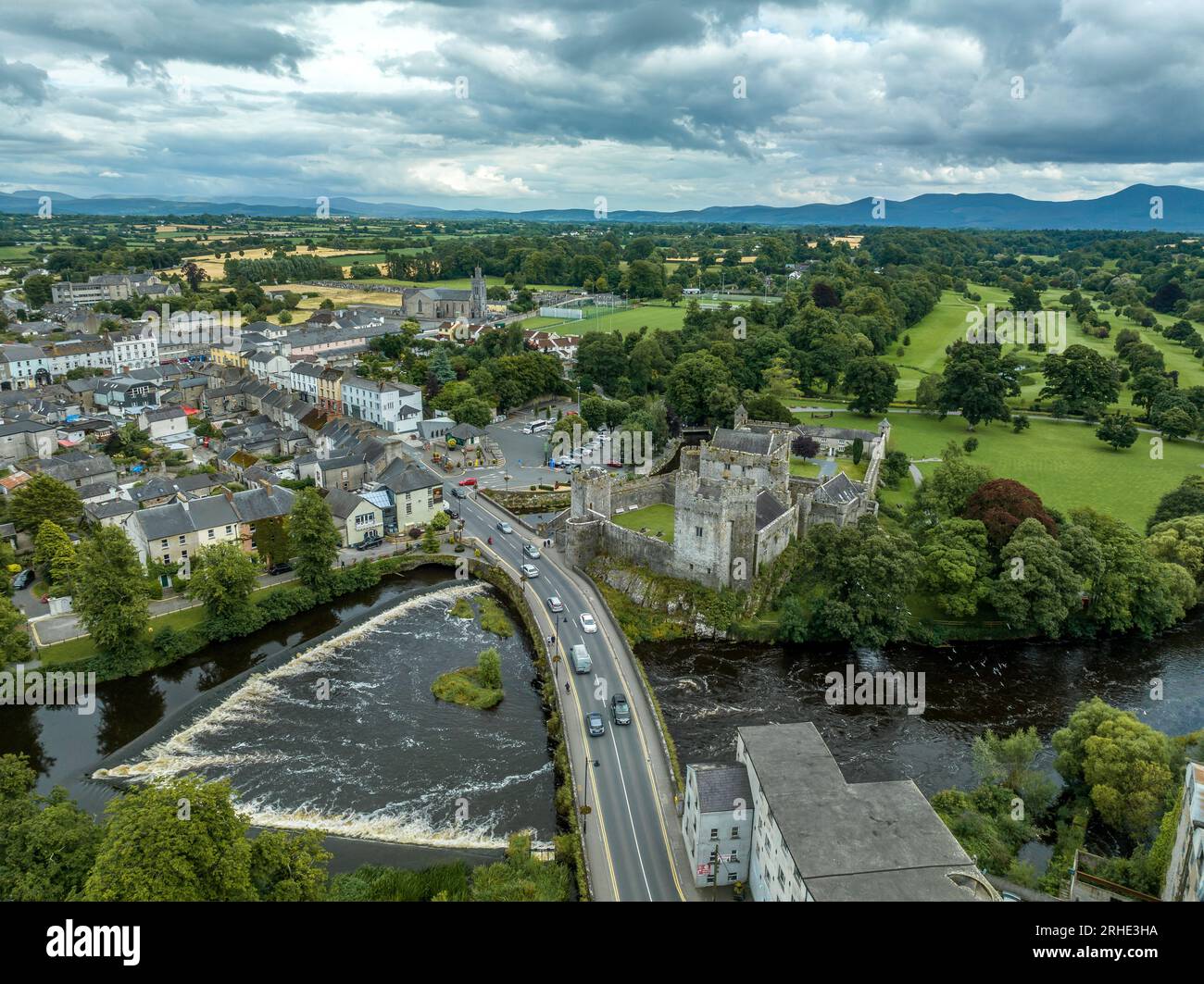 Aerial view of Cahir castle and town in Ireland with Tower House, outer castle, circular, rectangular towers, banquette hall, guarding the crossing Stock Photo