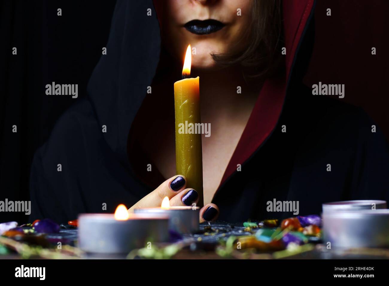 Witch hands performing a magic ritual holding a candle on a magical altar. Sorcerer rite of witchcraft and occultism. Halloween occult, esoteric and d Stock Photo