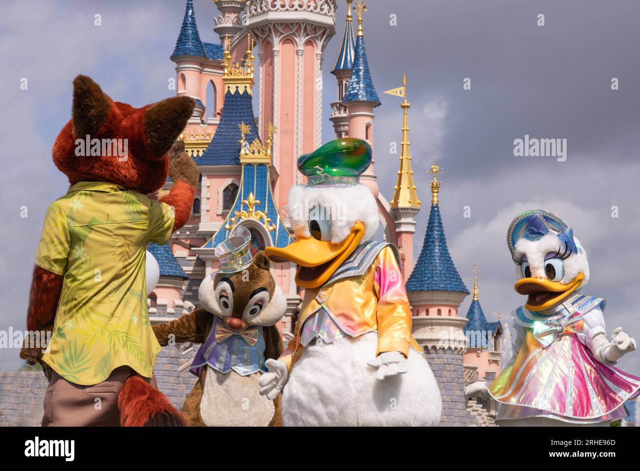 Disneyland Paris; Disney characters and the Disneyland Castle dancing in the Disneyland Parade; Nick Wilde the fox; Chip, Donald Duck and Daffy Duck Stock Photo