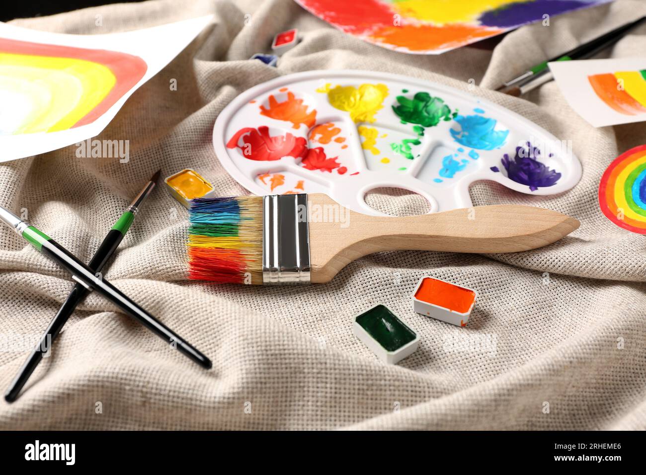 Paint brushes with paints and palette on bright background Stock Photo -  Alamy