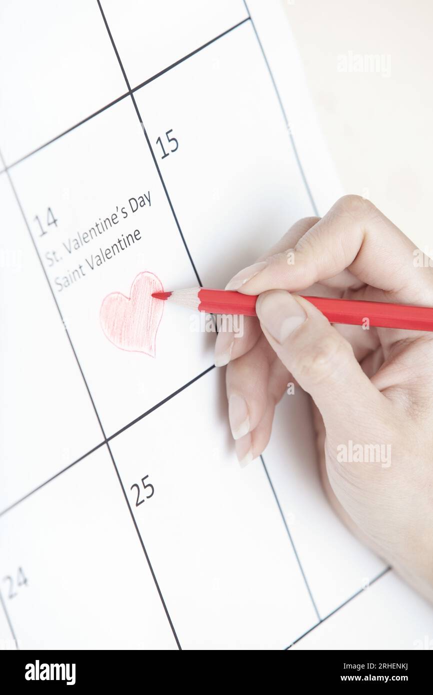 Woman hand drawing heart shape on a calendar Stock Photo - Alamy