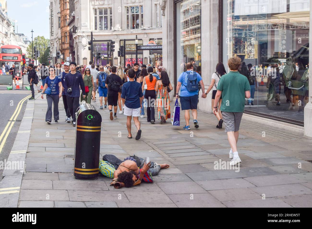 London, England, UK. 16th Aug, 2023. People walk past a homeless man lying on the pavement on Oxford Street as retail leaders warn that high streets are continuing to decline and call for government-backed regeneration. (Credit Image: © Vuk Valcic/ZUMA Press Wire) EDITORIAL USAGE ONLY! Not for Commercial USAGE! Stock Photo
