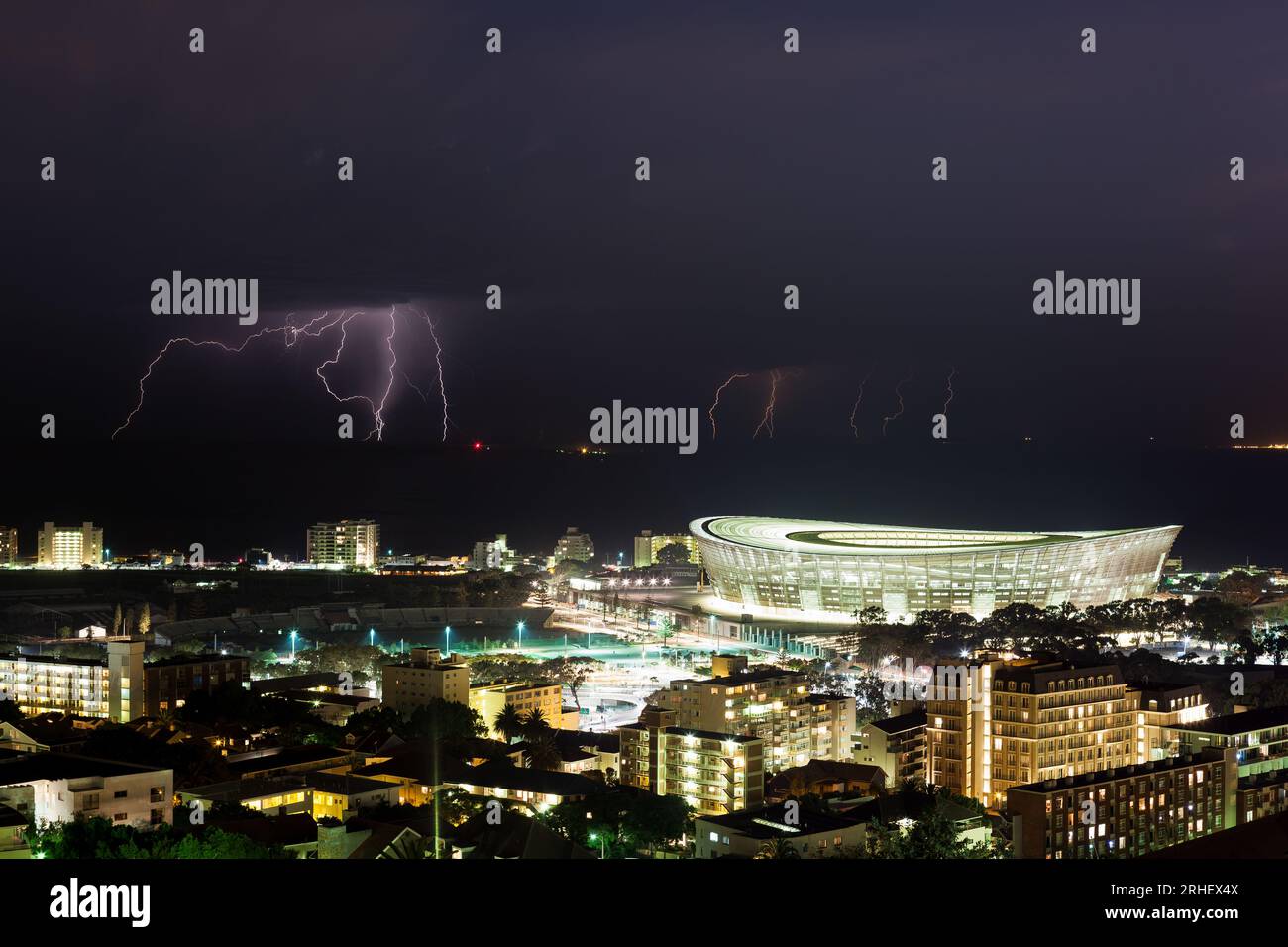 Night-scape Cape Town Stadium in Green Point South Africa with lightning storm over the Atlantic Ocean Stock Photo