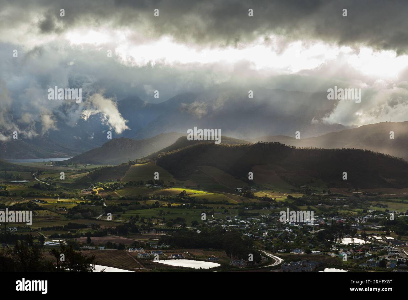 Rays of sun breaking through winter clouds over the town of Franschhoek, tourist wine region in South Africa Stock Photo